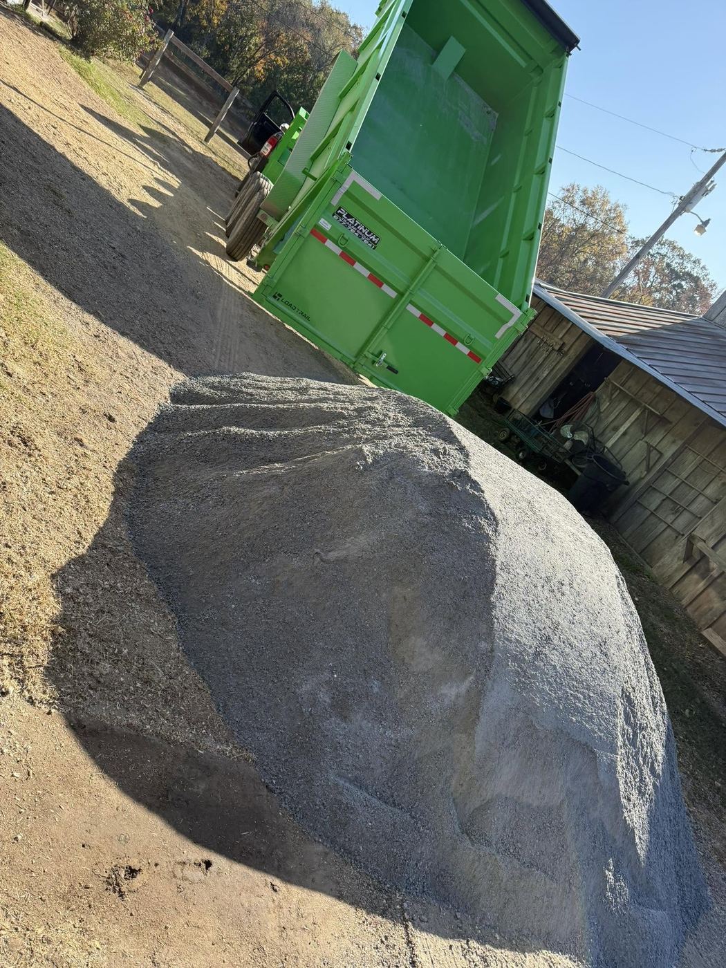 Dump truck spreading a load of gravel on a driveway